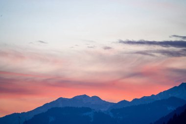 Himalaya dağlarının pembe mavi renkleri sise dönüşüyor. Manali Kullu 'nun Hindistan' daki kış ve yazlık tatil beldesinin huzurlu manzarasını gösteriyor.