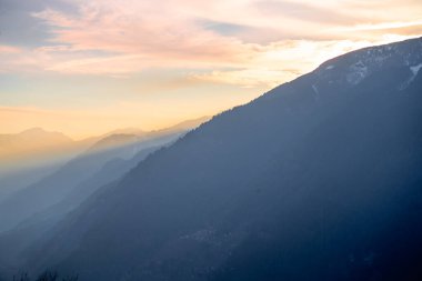 Himalaya dağlarının sakin manzarası Hamta köyü yürüyüşünden alacakaranlıkta güneş ışınlarının Hindistan 'daki Manali dağlarının arasından geçişini gösteriyor.