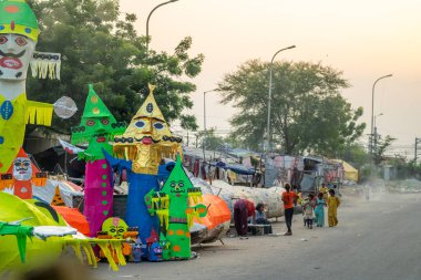 Jaipur, Rajasthan, India - 22nd oct 2023: People walking in front of huge colorful effigies of Ravana made of paper on the hindu festival of Dussehra Vijayadashami clipart