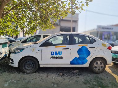 Delhi, Hindistan - 9. Mar 2024: Haling online uygulaması Blusmart Blu 'nun ağaç gölgesinde duran popüler EV arabaları