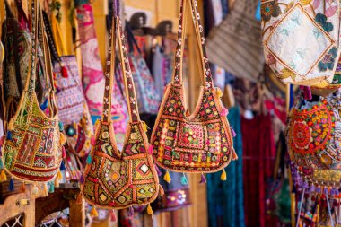 Renkli el yapımı, aynalı, nakışlı geleneksel rajasthani çantaları, bir sokak satıcılarının önünde asılı püskülleri turistlere satılmaya hazır Hindistan 'da.