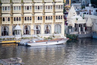 Geleneksel taş binalar, Udaipur 'daki Pichola Fateh Efsanesi' nin kıyısında su yollarında tekneleri olan restoranlar.
