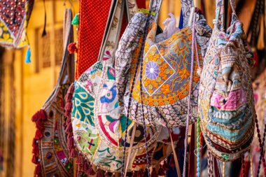 Renkli el yapımı, aynalı, nakışlı geleneksel rajasthani çantaları, bir sokak satıcılarının önünde asılı püskülleri turistlere satılmaya hazır Hindistan 'da.