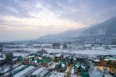 Karda yanan evleri gösteren hava aracı Phelgam 'ı kapladı rafting noktası vadisi Himalaya dağları ve Kashmir Hindistan' da günbatımı gökyüzü