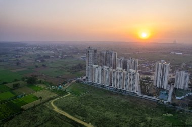 Havadan çekilen lüks, zengin, lüks binalar, ofis alışverişi için çevresi dağlarla çevrili yeşil tarlalar, doğanın ortasında yaşadığını gösteriyor.