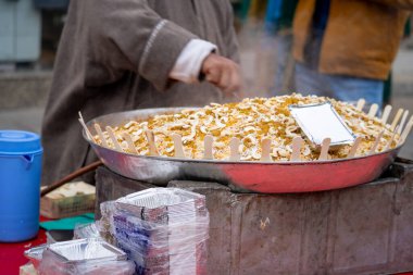 Gajar ka halwa havuç keki pişiren sokak yemekçisi üzerinde tahta kaşıklar olan tatlı bir tabağa konulmuş bayram yemeği, Diwali, Holi Kuzey Hindistan 'da