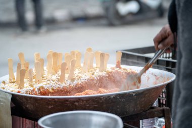 Gajar ka halwa havuç keki pişiren sokak yemekçisi üzerinde tahta kaşıklar olan tatlı bir tabağa konulmuş bayram yemeği, Diwali, Holi Kuzey Hindistan 'da