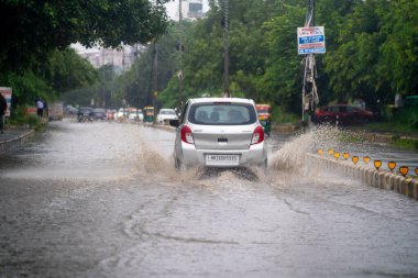Gurgaon, Delhi, Hindistan - 1 Eylül 2025: Ana yollarda, bozuk yollarda, çukurlarda ve muson yağmurlarında her gün karşılaşılan derin suların her tarafına su sıçrayan küçük araba