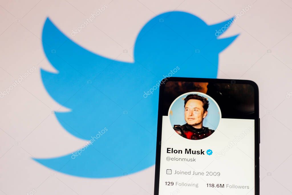 November 24, 2022, Brazil. In this photo illustration, the Elon Musk Twitter account displayed on a smartphone screen and Twitter logo displayed on a screen in the background
