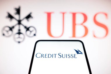 20 Mart 2023, Brezilya. Bu resimde Credit Suisse logosu arka planda bir akıllı telefon ve UBS logosu üzerinde gösteriliyor.