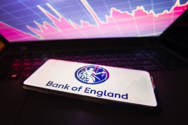 March 21, 2023, Brazil. In this photo illustration the Bank of England logo seen displayed on a smartphone screen, with graphic representation of the stock market in the background clipart