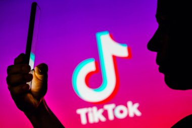 6 Nisan 2023, Brezilya. Bu resimde, bir kadının siluetinde arka planda TikTok logosu olan bir akıllı telefon var.