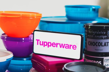 12 Nisan 2023, Brezilya. Bu resimde, akıllı telefonun yanında Tupperware logosunu gösteren çeşitli plastik ürünler yığını var.