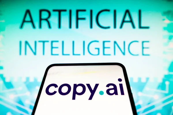 stock image April 19, 2023, Brazil. In this photo illustration, the Copy AI logo is displayed on a smartphone screen and in the background the text artificial intelligence
