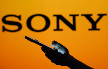 13 Haziran 2023, Brezilya. Bu resimde Sony logosu cep telefonu tutan siluet bir kadının arka planında görülüyor.