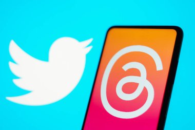 5 Temmuz 2023, Brezilya. Bu fotoğraf illüstrasyonunda, İplik logosu akıllı telefon ekranında gösteriliyor. Tartışmalar Meta Platformları 'nın yeni sosyal ağı. Arka planda, Twitter logosu