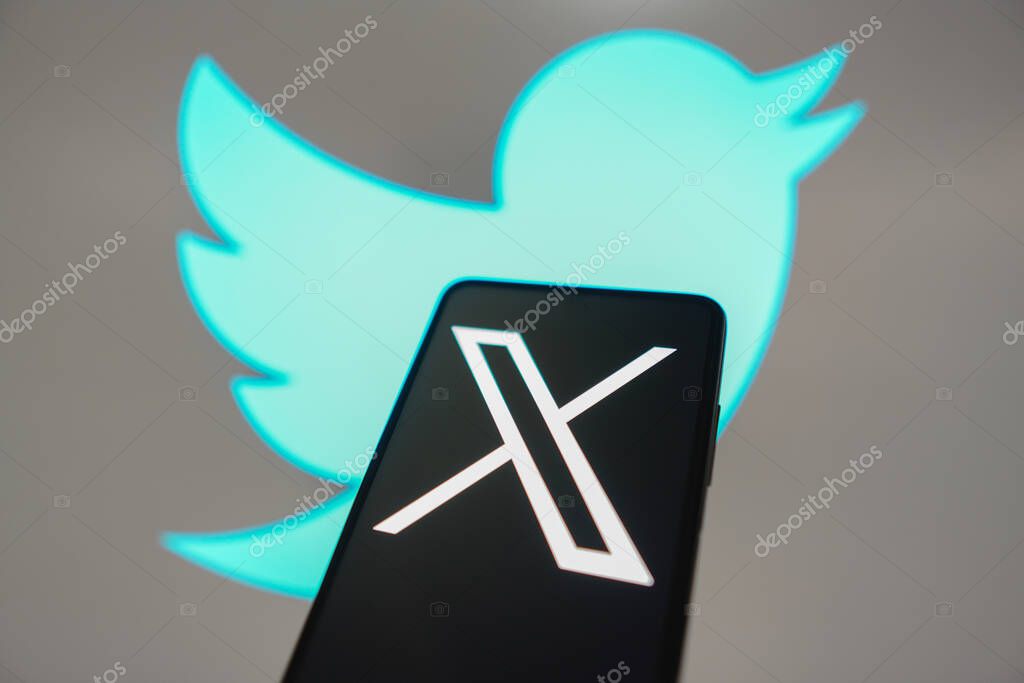 July 24, 2023, Brazil. In this photo illustration, the Twitter (X) new logo seen displayed on a smartphone. In the background, the old bluebird social network logo