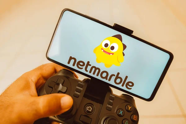 2023年8月11日 在这张照片中 一个人在操纵杆上玩 Netmarble的标志显示在智能手机屏幕上 — 图库照片