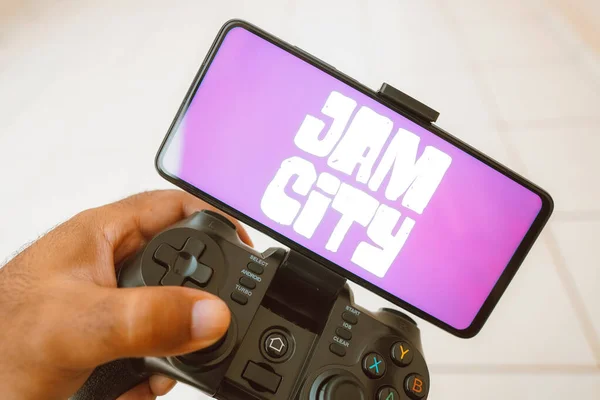 2023年8月11日 在这张照片中 一个人在操纵杆上玩耍 Jam City的标志显示在智能手机屏幕上 — 图库照片