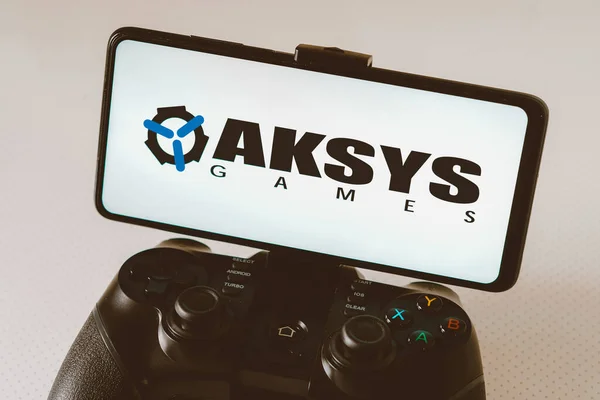 2023年8月14日 巴西在这张照片中 Aksys Games标志显示在智能手机屏幕上 与游戏控制杆相连 — 图库照片