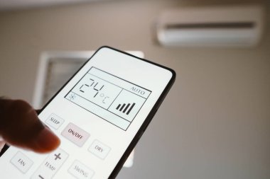 16 Kasım 2023, Brezilya. Bu resimde, bir kişi klimanın uzaktan kumandasındaki oda sıcaklığını ayarlıyor. BM 'ye göre, Dünya gezegeni atmosferdeki en yüksek karbondioksit yoğunluğuna sahip.