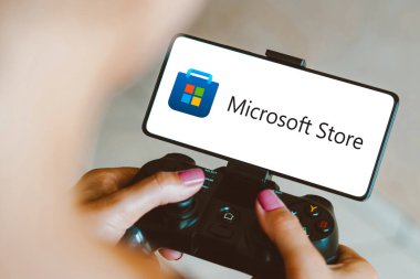 4 Aralık 2023, Brezilya. Bu fotoğraf illüstrasyonunda, Microsoft Store logosu bir oyun platformunda oynayan bir kişi olarak akıllı telefon ekranında görüntülenir