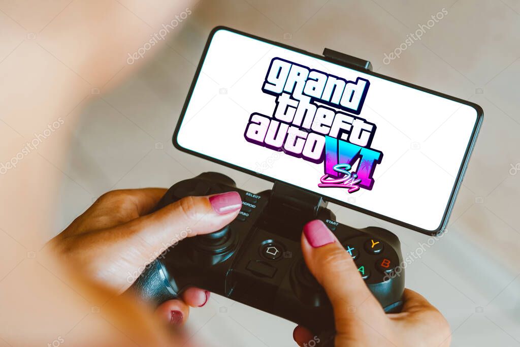 December 5, 2023, Brazil. In this photo illustration, the Grand Theft Auto VI (GTA 6) logo is displayed on a smartphone screen as a person plays on a gaming gamepad