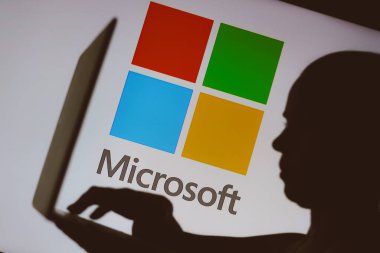9 Ocak 2024, Brezilya. Bu resimde, Microsoft logosu bir kişinin siluetinin arka planında bir defter kullanarak görülüyor.