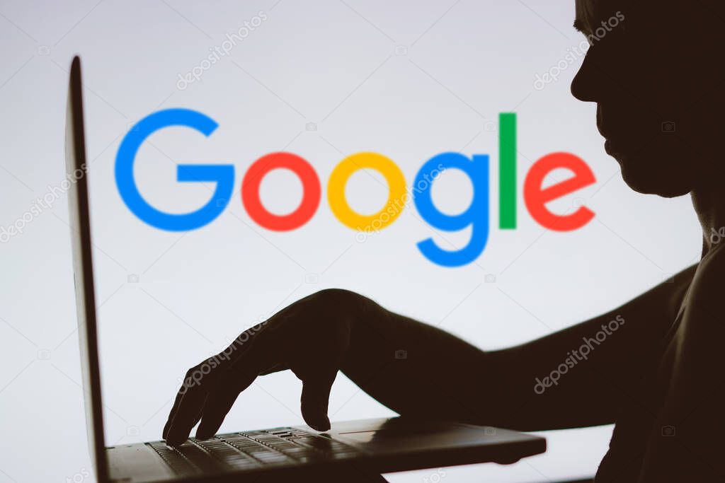 January 24, 2024, Brazil. In this photo illustration, the Google logo is seen in the background of a silhouette of a person using a notebook