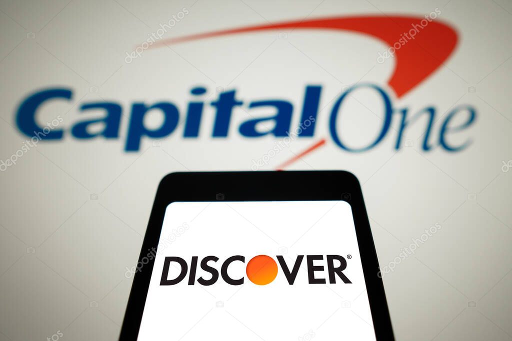 February 19, 2024, Brazil. In this photo illustration, the Discover Financial Services logo is displayed on a smartphone screen with the logo Capital One Financial in the background. Capital One said to be in talks to acquire Discover. The proposed d