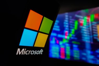15 Mart 2024, Brezilya. Bu fotoğraf illüstrasyonunda, Microsoft Corporation logosu bir akıllı telefon ekranında sergilenmekte ve arka planda borsanın grafik temsili bulunmaktadır.