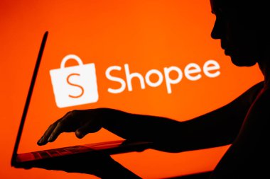 28 Mart 2024, Brezilya. Bu resimde, Shopee logosu bir defter kullanan bir kişinin siluetinin arka planında görülüyor.