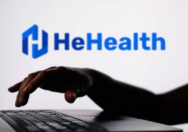 28 Mart 2024, Brezilya. Bu resimde, HeHealth logosu bir defterle siluetinin arka planında görülüyor.