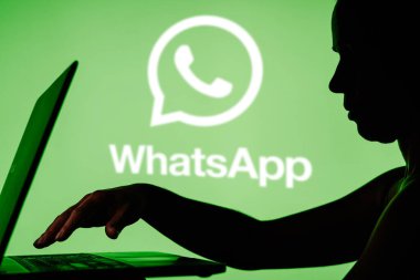 29 Mart 2024, Brezilya. Bu resimde WhatsApp logosu, defter kullanan bir kişinin siluetinin arka planında görülüyor.