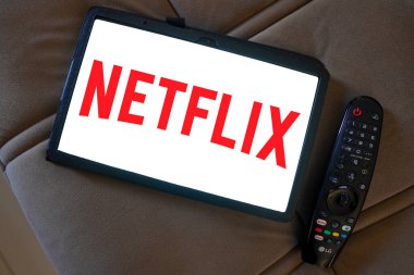 20 Nisan 2024, Brezilya. Bu fotoğraf illüstrasyonunda, Netflix üzerinden küresel film ve dizi sağlayıcısının logosu bir sonraki Tv uzaktan kumandası olan bir tablette görüntülenir.