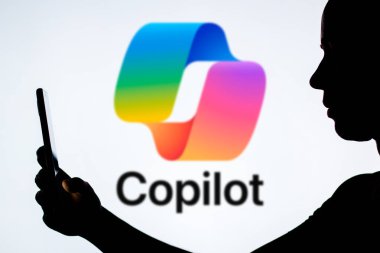 13 Mayıs 2024, Brezilya. Bu resimde, bir kadının siluetinde arka planda Microsoft Copilot logosu olan bir akıllı telefon var.
