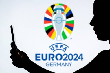 20 Mayıs 2024, Brezilya. Bu resimde, arka planda UEFA Avrupa Futbol Şampiyonası (Euro 2024 Almanya) logosu bulunan bir kadın silueti yer almaktadır.