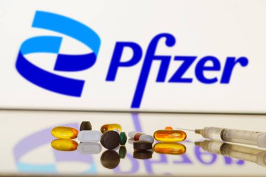 27 Mayıs 2024, Brezilya. Bu resimde, Pfizer logosu arka planda ilaç, ilaç şişesi ve şırınga ile ekranda gösteriliyor.