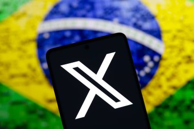 August 17, 2024, Paraguay. In this photo illustration, the X (Twitter) logo is displayed on a smartphone screen and the flag of Brazil in the background. Social network X announces that it will close its office in Brazil clipart