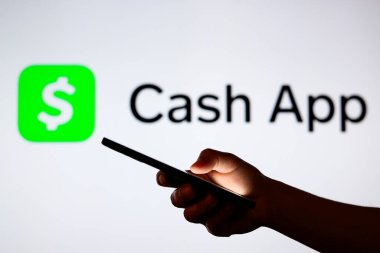 11 Eylül 2024, Paraguay. Bu resimde, Cash App logosu arka planda bir siluet elle akıllı telefon tutarken görülüyor.
