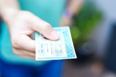 Man holds National Driver's License (CNH). Official document of Brazil, which attests the ability of a citizen to drive land vehicles clipart