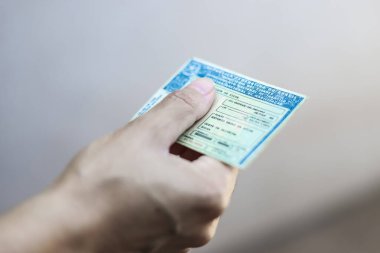 Man holds National Driver's License (CNH). Official document of Brazil, which attests the ability of a citizen to drive land vehicles clipart