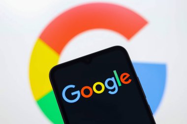 Google logosu bir akıllı telefon ekranında ve arka plandaki bilgisayar ekranında 15 Kasım 2024 'te Reno, ABD' de gösterilir.