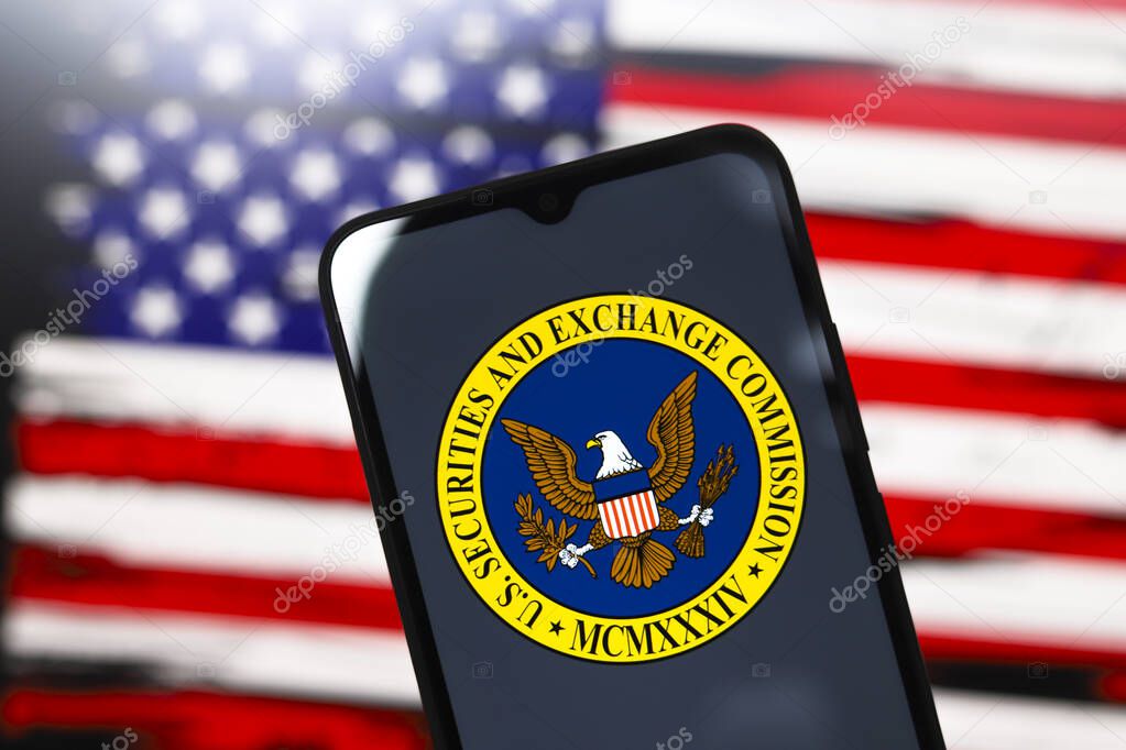 The United States Securities and Exchange Commission (SEC) logo appears on the screen of a smartphone and in the background the flag of the United States on the computer screen, in Reno, United States, on December 3, 2024