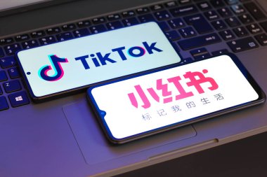 Bu resimde, Xiaohongshu (Rednote) ve TikTok logoları 17 Ocak 2025 'te Reno, Amerika Birleşik Devletleri' nde bir dizüstü bilgisayarın yanında bir akıllı telefon ekranında görüntülenmektedir.