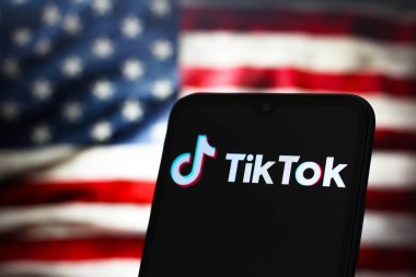 Bu fotoğraf illüstrasyonunda, TikTok logosu akıllı telefon ekranında ve arka planda, ABD bayrağı, 17 Ocak 2025 'te Reno, ABD' de sergilenmektedir.