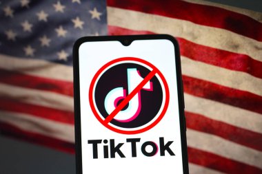 Bu fotoğraf illüstrasyonunda, TikTok logosu akıllı telefon ekranında ve arka planda, ABD bayrağı, 17 Ocak 2025 'te Reno, ABD' de sergilenmektedir.