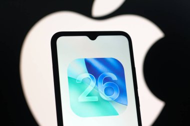 Bu resimde, Apple iOS 26 logosu bir akıllı telefon ekranında görüntülenmektedir.