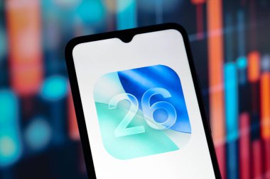 Bu resimde, Apple iOS 26 logosu bir akıllı telefon ekranında görüntülenmektedir.