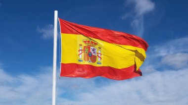 Flag of Spain on a blue sky clipart